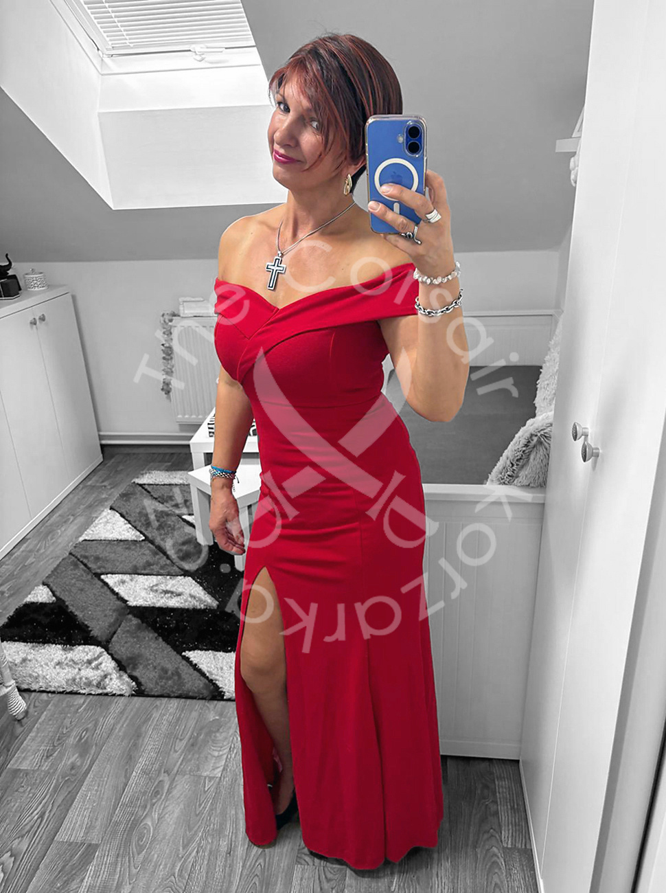 Findom Mistress Korzárka v červených šatech, černých lodičkách a se stříbrnými šperky.